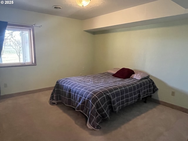 carpeted bedroom with visible vents and baseboards