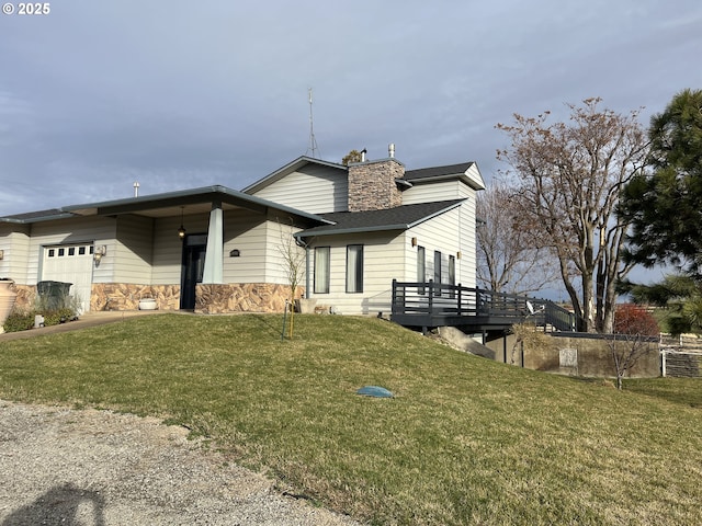 view of front of property featuring an attached garage, stone siding, a deck, and a front lawn