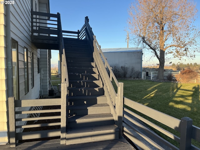 wooden deck with stairway, an outdoor structure, and a lawn