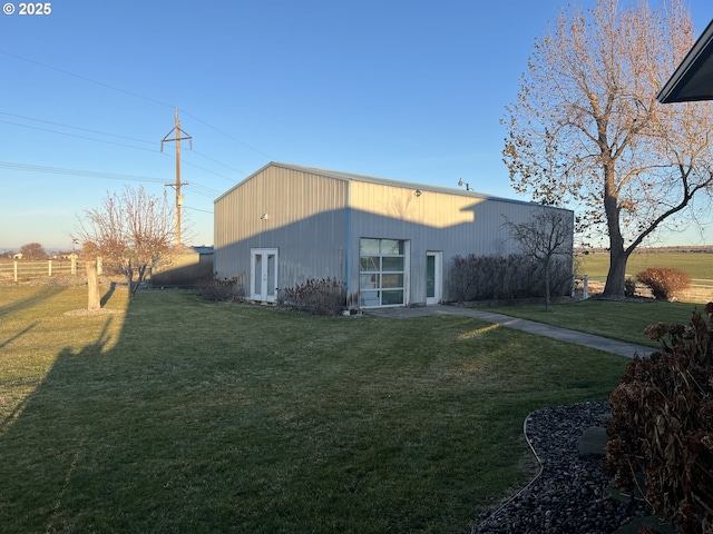 back of house with a pole building, an outdoor structure, and a lawn
