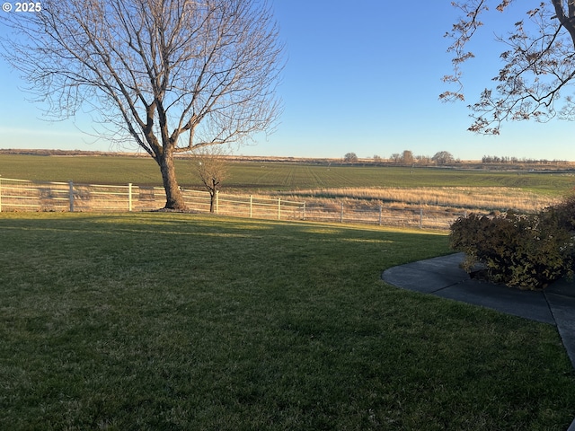 view of yard featuring fence and a rural view