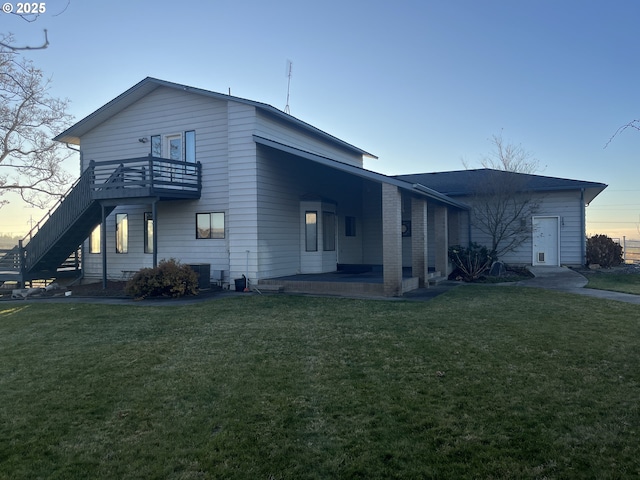 exterior space featuring central AC, a lawn, and a balcony