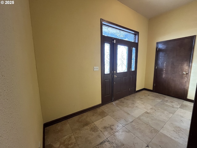 foyer entrance featuring baseboards