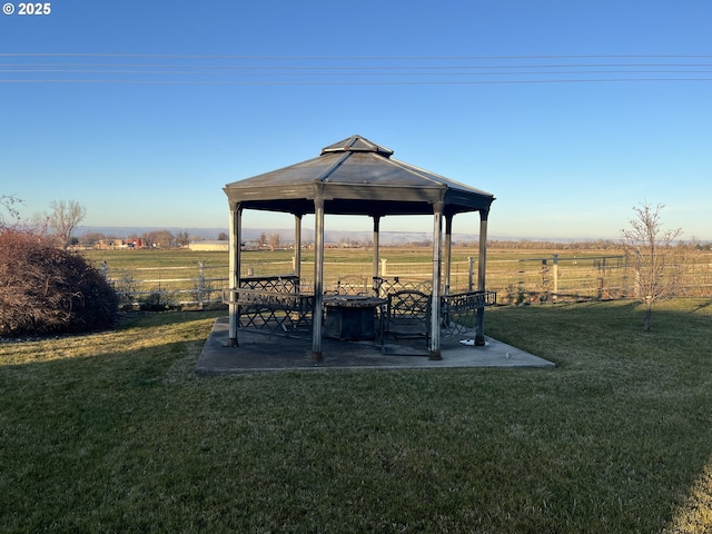 view of yard with a gazebo, fence, a patio, and a rural view
