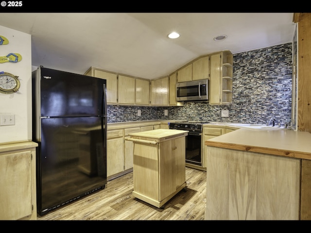 kitchen featuring black appliances, lofted ceiling, light hardwood / wood-style floors, a center island, and light brown cabinets