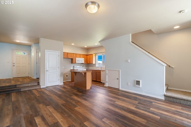 8465 S Hollyhock St, Rockaway Beach, OR 97136 - kitchen featuring white appliances, dark wood-style floors, a center island, recessed lighting, and a breakfast bar area