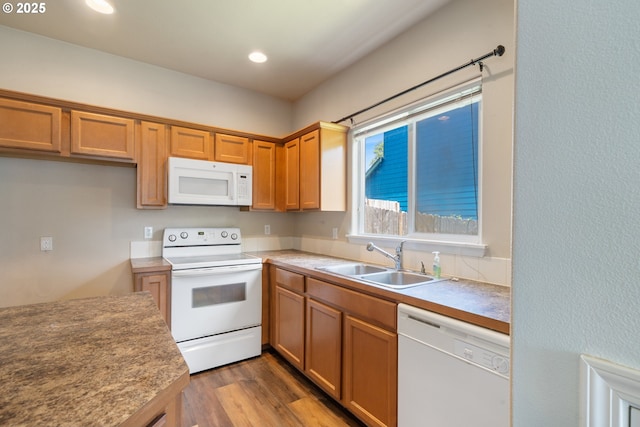8465 S Hollyhock St, Rockaway Beach, OR 97136 - kitchen with white appliances, wood finished floors, recessed lighting, and brown cabinets