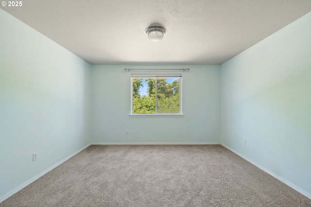 8465 S Hollyhock St, Rockaway Beach, OR 97136 - carpeted spare room featuring baseboards and a textured ceiling