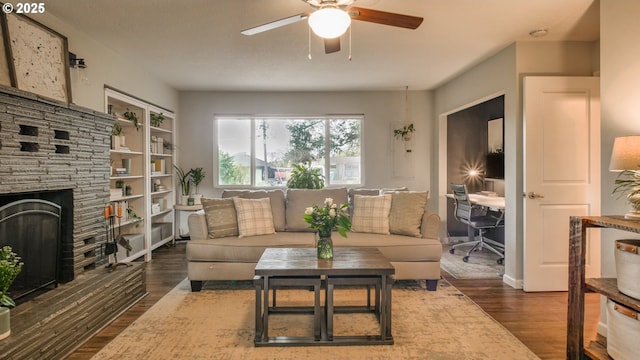 living room with a fireplace, a ceiling fan, and wood finished floors