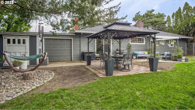 exterior space featuring an attached garage, a patio, a gazebo, and fence