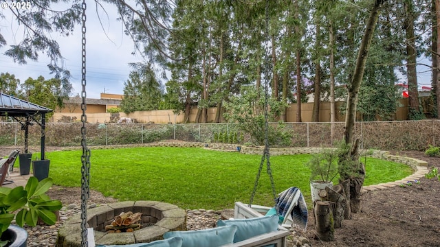 view of yard with a fenced backyard and a fire pit