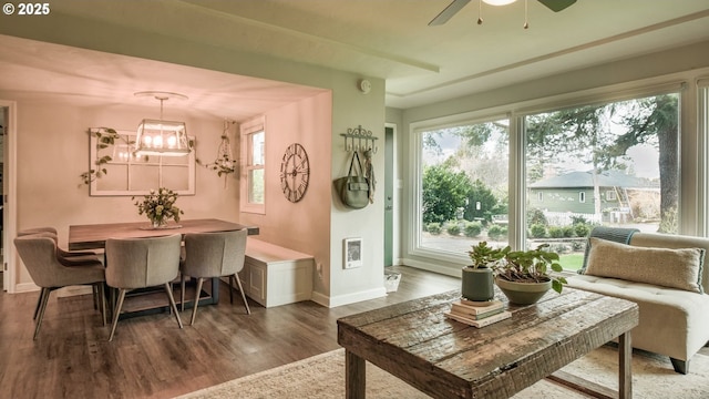 sunroom featuring ceiling fan with notable chandelier