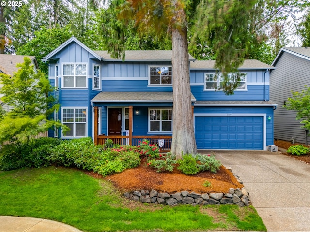21390 SW Roellich Ave, Sherwood, OR 97140 - view of front of house featuring board and batten siding, concrete driveway, an attached garage, covered porch, and a front lawn
