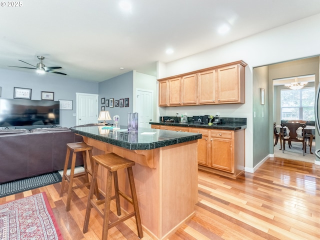 21390 SW Roellich Ave, Sherwood, OR 97140 - kitchen with light wood-style floors, a kitchen breakfast bar, open floor plan, tile countertops, and a kitchen island