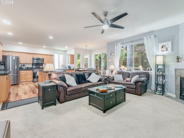 21390 SW Roellich Ave, Sherwood, OR 97140 - living area featuring light colored carpet, a ceiling fan, recessed lighting, a fireplace, and baseboards