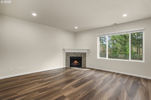 unfurnished living room with dark wood finished floors, visible vents, recessed lighting, and baseboards