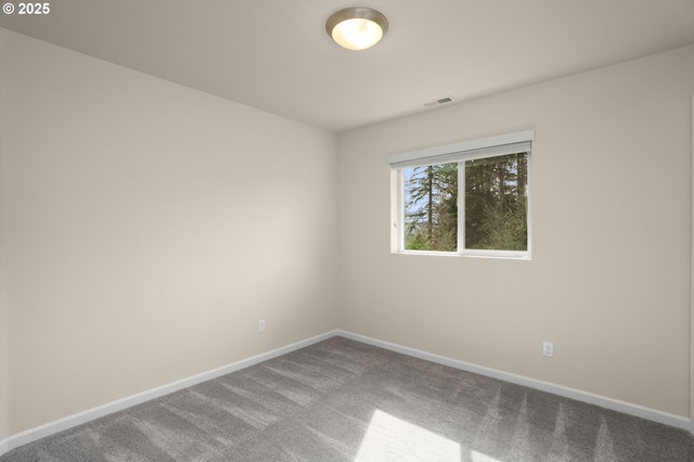 unfurnished room with visible vents, baseboards, and carpet floors