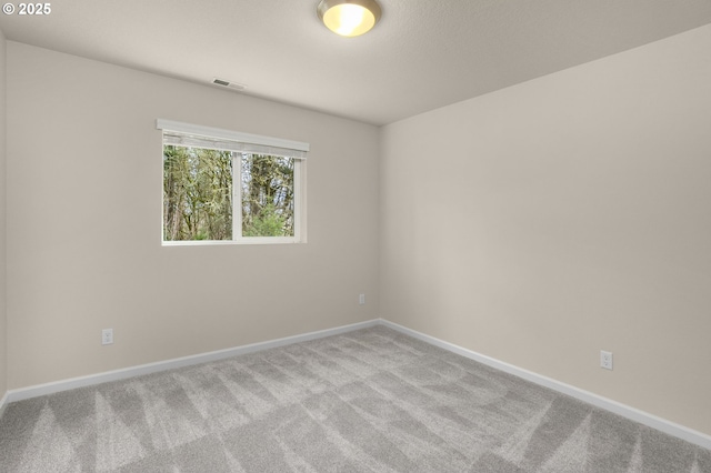 carpeted empty room with visible vents and baseboards