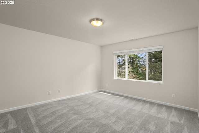 carpeted empty room with baseboards