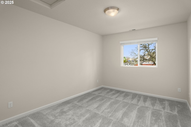 carpeted spare room featuring visible vents and baseboards