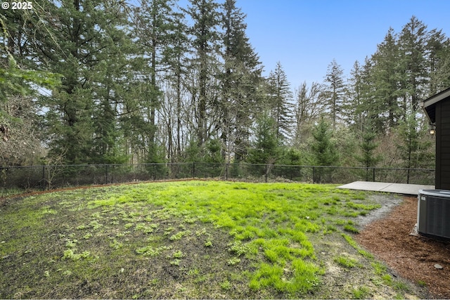 view of yard with central AC unit and fence