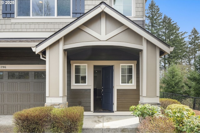 entrance to property featuring a garage and fence