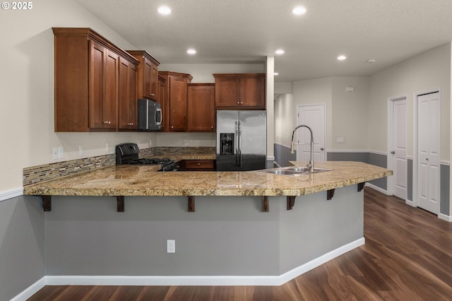 kitchen with dark wood-type flooring, light countertops, recessed lighting, appliances with stainless steel finishes, and a sink