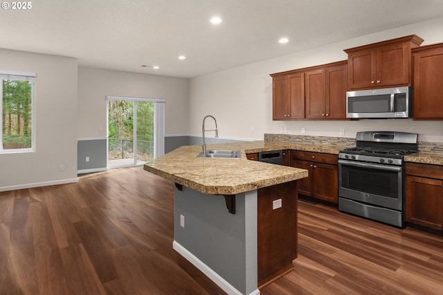 kitchen featuring a sink, appliances with stainless steel finishes, a peninsula, light countertops, and dark wood-style flooring