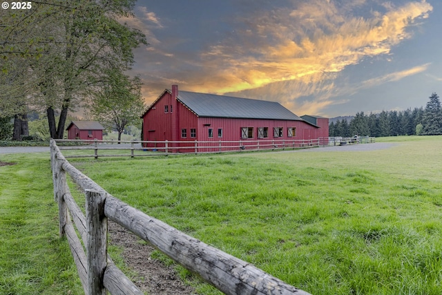 exterior space featuring a rural view, an outbuilding, fence, and a pole building