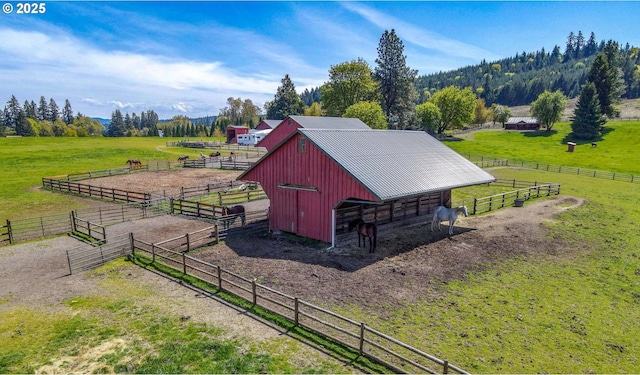 view of outbuilding with an outdoor structure, a rural view, and an exterior structure