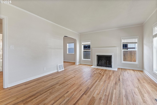 15234 SE Stark St, Portland, OR 97233 - unfurnished living room featuring arched walkways, ornamental molding, light wood-style flooring, and a fireplace with flush hearth