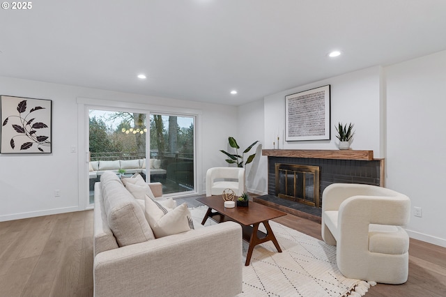 living area with recessed lighting, light wood-style floors, and baseboards