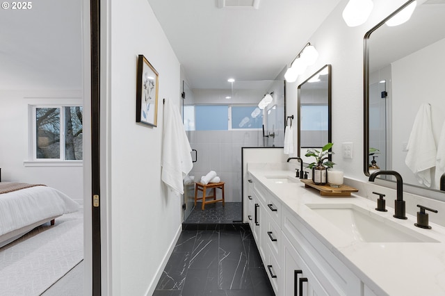 ensuite bathroom featuring a shower stall, double vanity, marble finish floor, and a sink