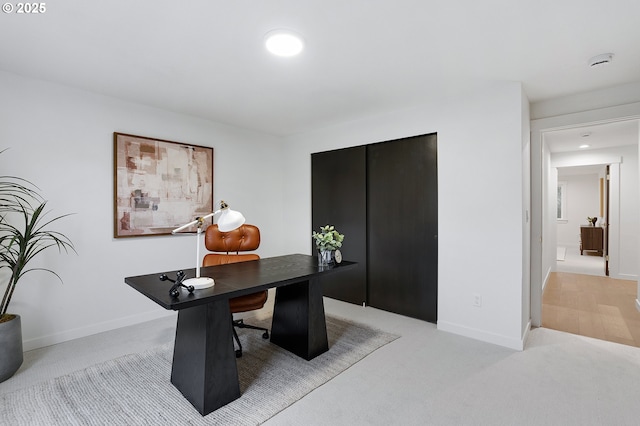 home office with light carpet and baseboards