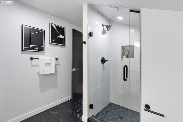 full bathroom with marble finish floor, a stall shower, and baseboards