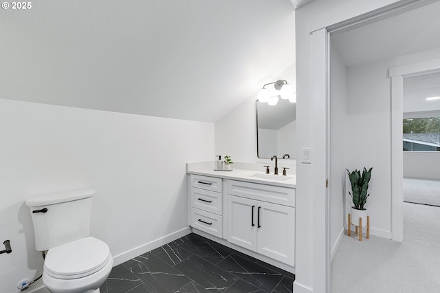 bathroom featuring vanity, baseboards, lofted ceiling, toilet, and marble finish floor