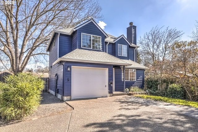 traditional-style house with a chimney, driveway, a shingled roof, and an attached garage