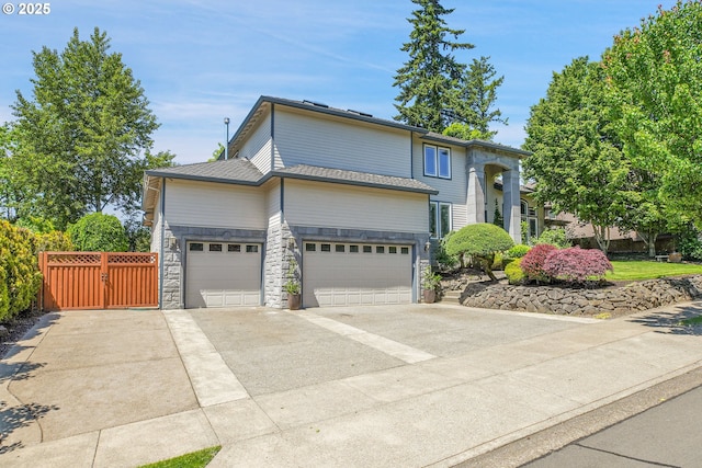 9459 SE Tarnahan Dr, Happy Valley, OR 97086 - bi-level home with stone siding, driveway, a garage, and a gate