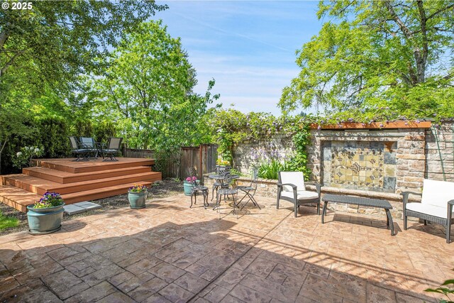 9459 SE Tarnahan Dr, Happy Valley, OR 97086 - fenced backyard with a wooden deck, outdoor dining space, and a patio area
