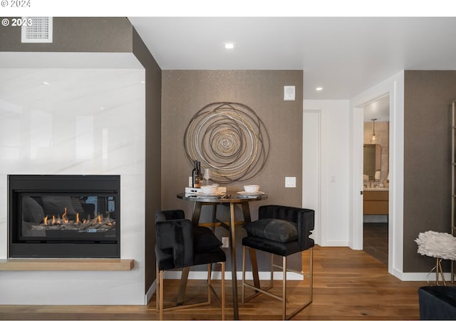 dining room featuring recessed lighting, a fireplace, baseboards, and wood finished floors