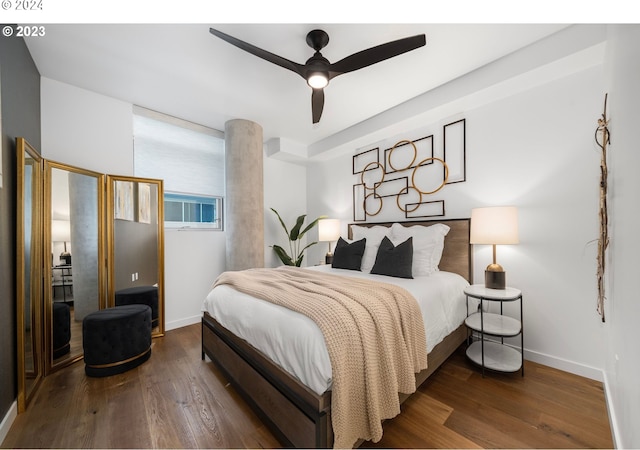 bedroom featuring baseboards, wood finished floors, and a ceiling fan