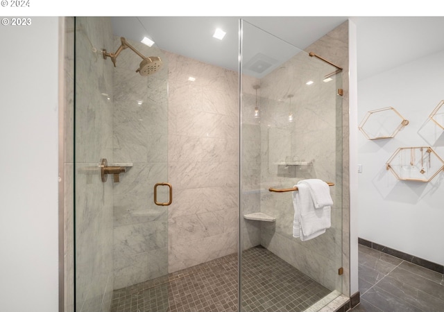 bathroom featuring a shower stall and baseboards