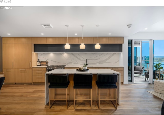 kitchen with decorative backsplash, modern cabinets, visible vents, and light wood finished floors