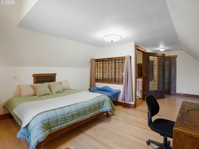 131 NE Tillamook St, Portland, OR 97212 - bedroom with vaulted ceiling, wood finished floors, and baseboards