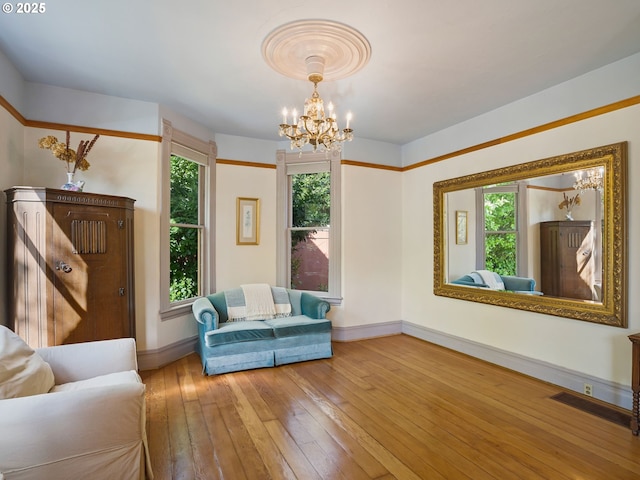 131 NE Tillamook St, Portland, OR 97212 - living room featuring a chandelier, healthy amount of natural light, hardwood / wood-style floors, and baseboards