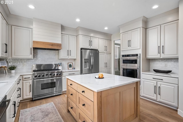 kitchen featuring decorative backsplash, a kitchen island, white cabinetry, and appliances with stainless steel finishes