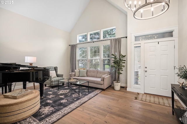 interior space with hardwood / wood-style floors, high vaulted ceiling, and an inviting chandelier