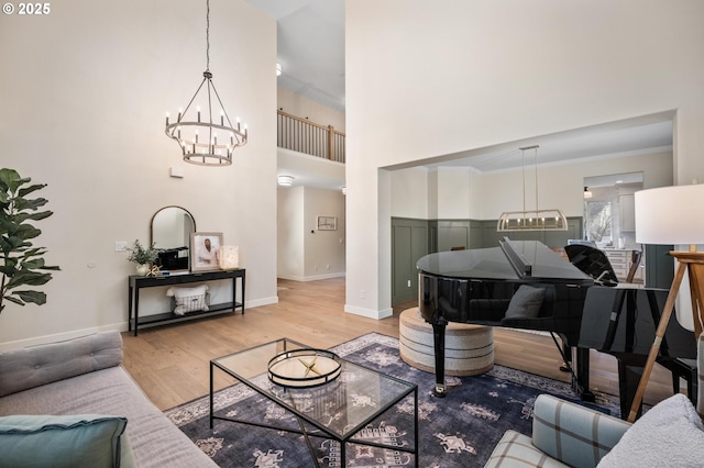 living room featuring crown molding, wood-type flooring, and a notable chandelier