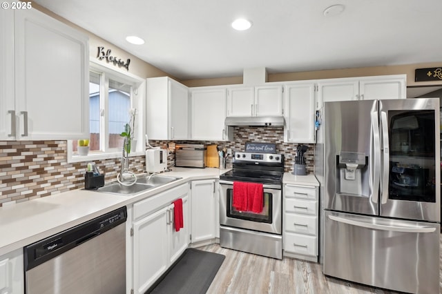 kitchen with stainless steel appliances, sink, white cabinets, and decorative backsplash