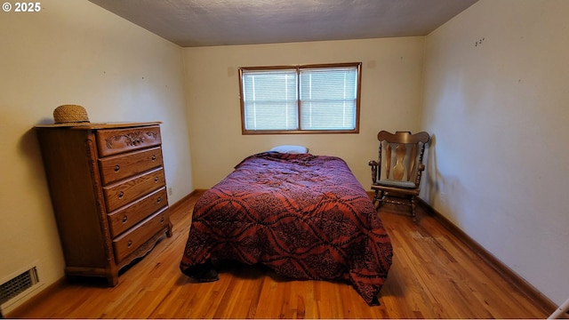 bedroom with visible vents, baseboards, and light wood-style flooring